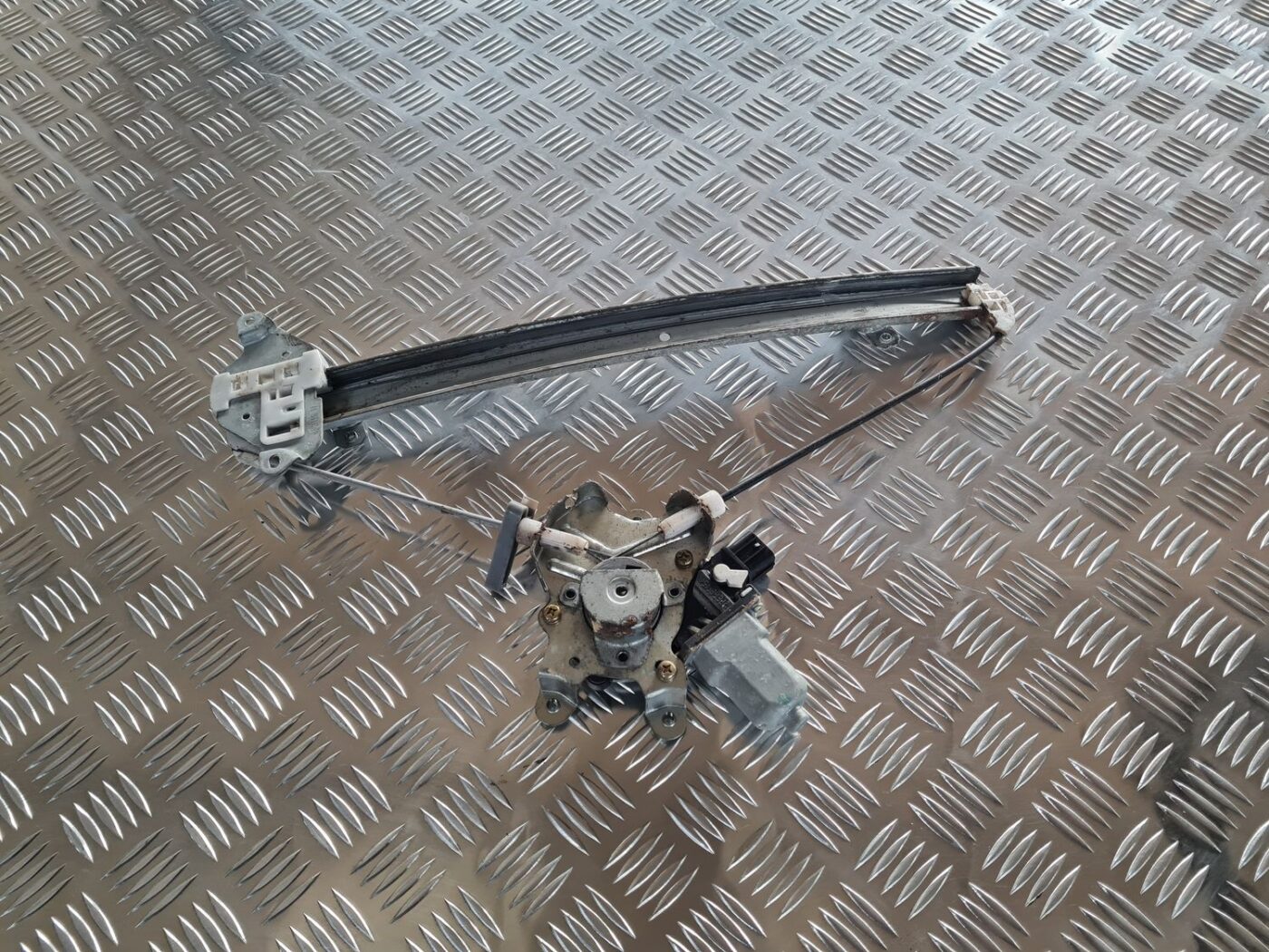 Stikla pacelšanas mehānisms priekšējais kreisais priekš MITSUBISHI LANCER 2006